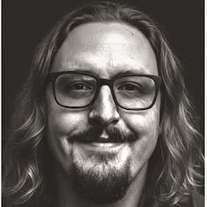 Black and white Photo of Bradley Fisher wearing black glasses and smiling. 