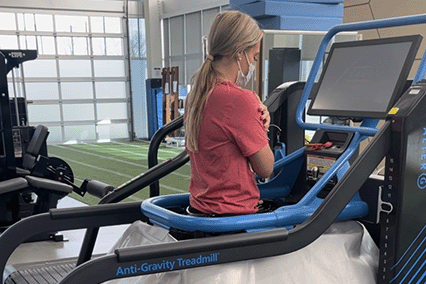 Child using an anti-gravity treadmill during a rehabilitation or physical therapy session in a clinical exercise facility