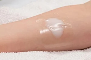 Lidocaine cream applied to a child's lower arm before a medical procedure or vaccination.