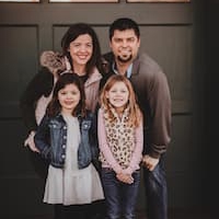 image of family of 4 posing for family portrait outside