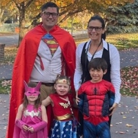 photo of family of five posing for a photo outside wearing superhero costumes