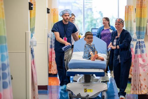 image of patient in hospital bed with team members at the side
