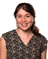 Emily Hurley, PhD, MPH. Emily has brown hair, pulled back in a ponytail. She is wearing a shirt in colors of brown and light pink.