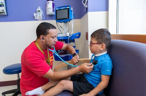 image of clinician listening to heart of patient