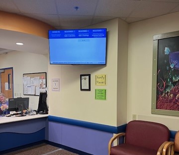Digital display screen showing patient registration and wait status information for families