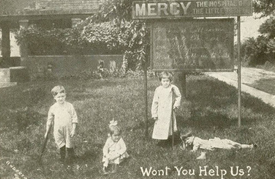 Historic fundraising photograph showing children outside the original Children's Mercy hospital, with signage identifying the hospital and a message asking for support.