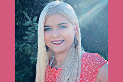 Portrait of a person with long light-colored hair wearing a patterned top