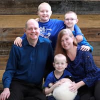 image of a family of five posing for a family picture, all wearing blue shirts