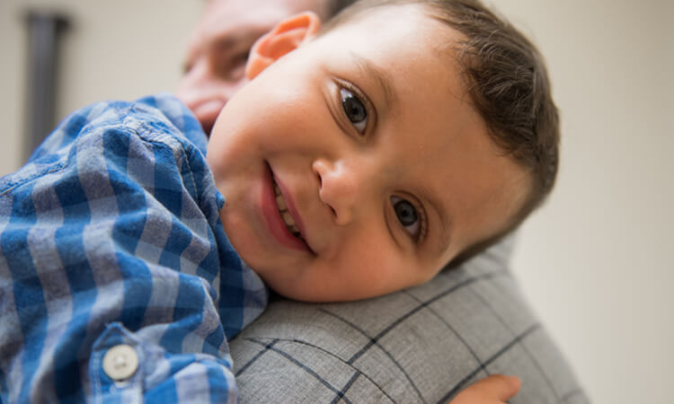 smiling child being held by an adult