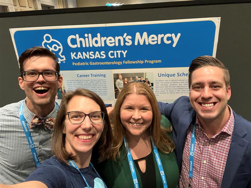 team members gather in front of a scientific poster