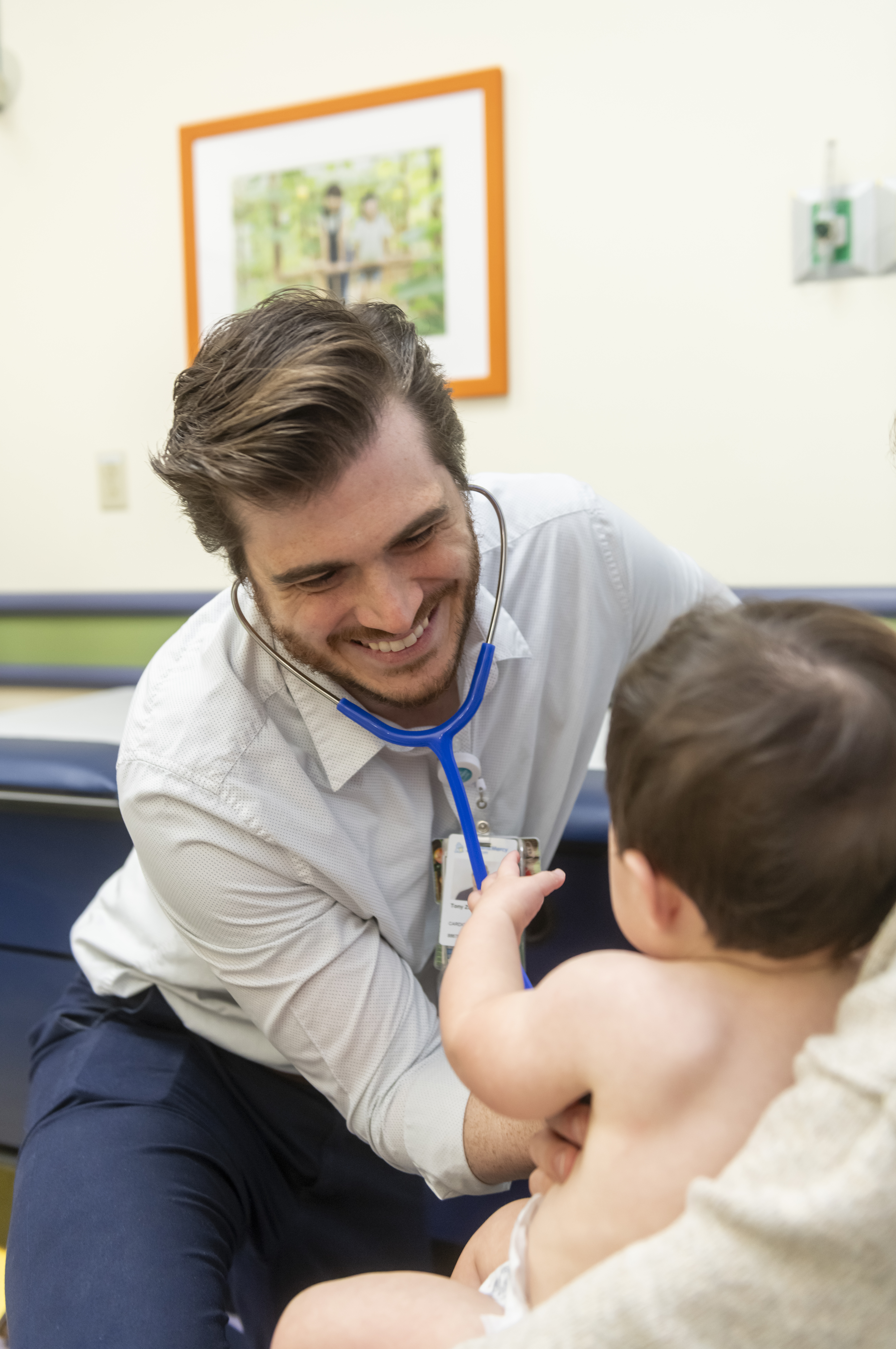 photo of a Fellow with a young patient in an exam room