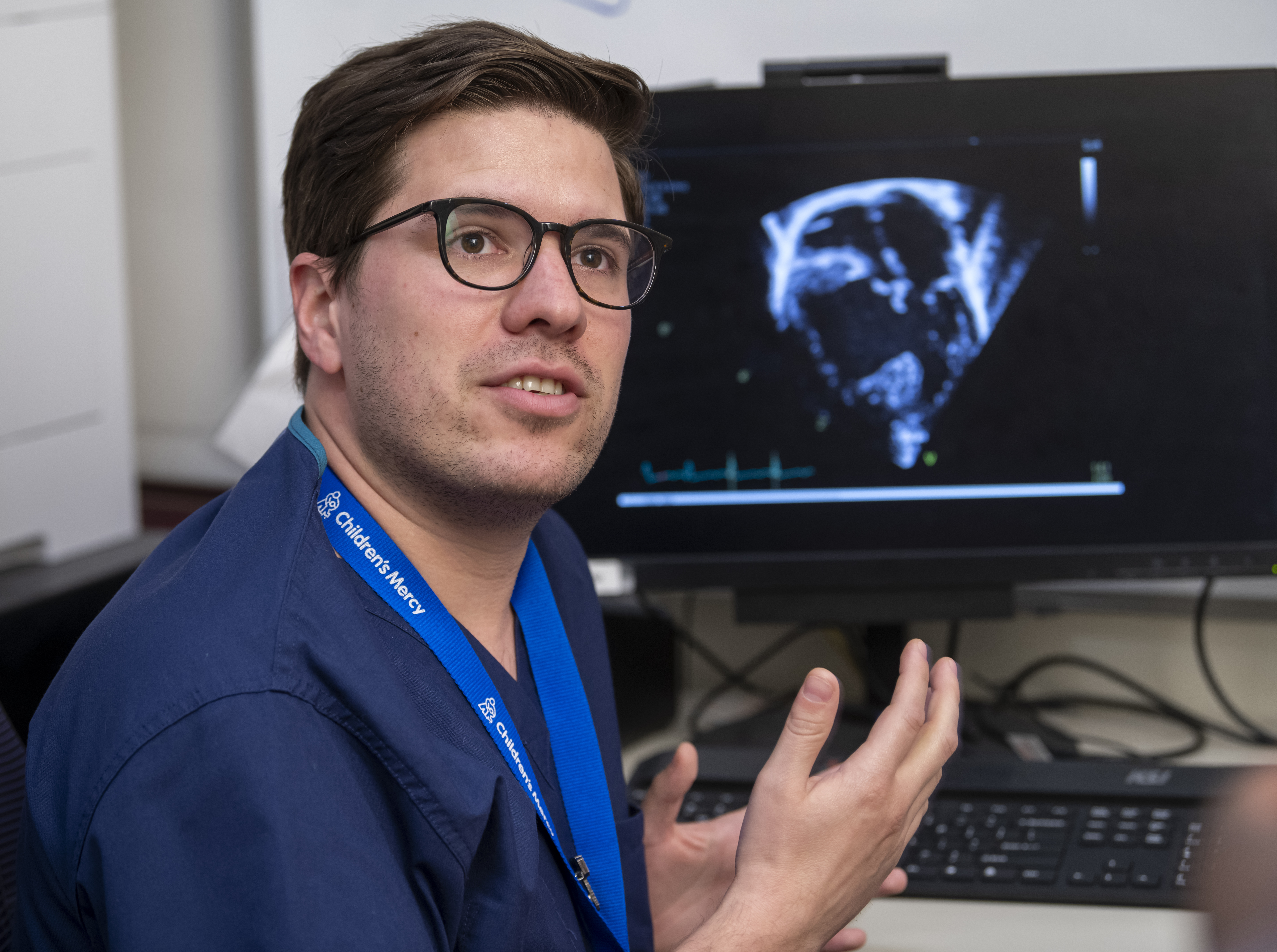 photo of a Fellow in front of a computer that is showing a medical image