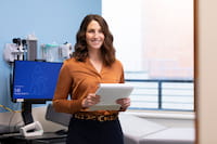 photo of a nurse smiling in a clinic room