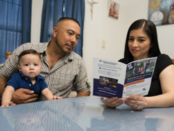 Family reading study information at table.