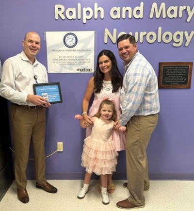 The Sargent family with Dr. John-Baptiste Le Pichon. Mom and dad stand with Maddie, their daughter, on the right. Dr. Le Pichon stands on the left holding an award.