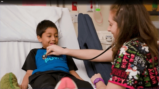 Health care team member listening to a child's heartbeat with a stethoscope