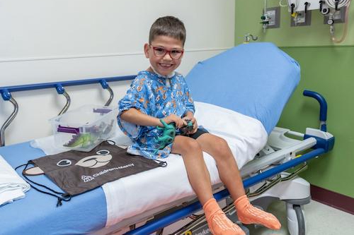 image of patient smiling at bedside with a toy 