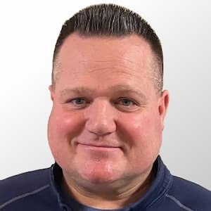 George Vielhauer in a navy blue zip up with white background. 