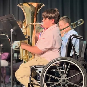 child playing at indoor music concert with a tuba