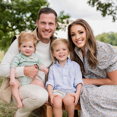 family of 4 posing for a photo outside