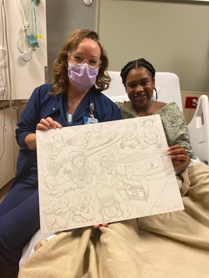 Mom Taylor and nurse Sarah holding drawing of angel babies. 