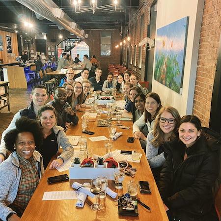 Children's Mercy Residents gather around a long table during a team dinner at a local restaurant.