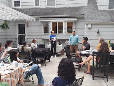 team members gathering outside a home for a cultural night event