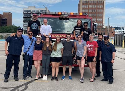 photo of residents participating in local event standing with firetruck