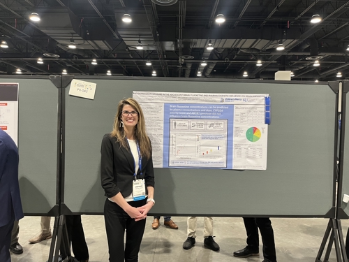 Dr. Stancil stands next to her poster presentation at the 2024 American Society for Clinical Pharmacology and Therapeutics Annual Meeting.