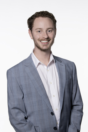 Jack Frank. He is wearing a blue and light grey light plain blazer with a white shirt underneath. 