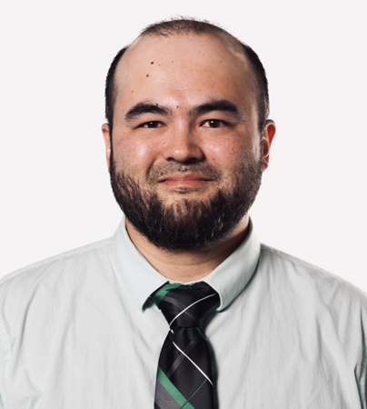 John Means. He is wearing a green and black striped tie with a button-up, collared shirt.