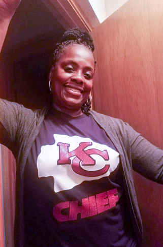 Tammy Basey. Her black hair is pulled up. She's wearing a Kansas City Chiefs shirt.