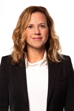 Elin Grundberg, PhD. She has blonde hair that falls below her shoulders. She is wearing a white turtleneck and a black blazer.
