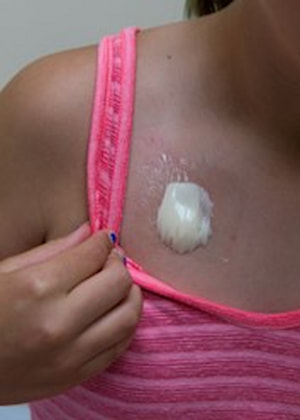 Close-up of a child applying a cream or ointment